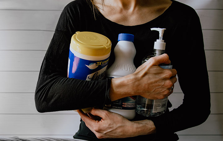 woman holding cleaning products