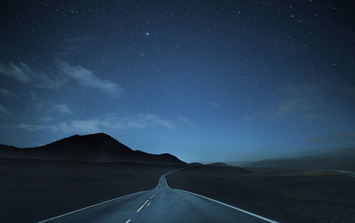 starry sky, silhouette of mountains, and highway
