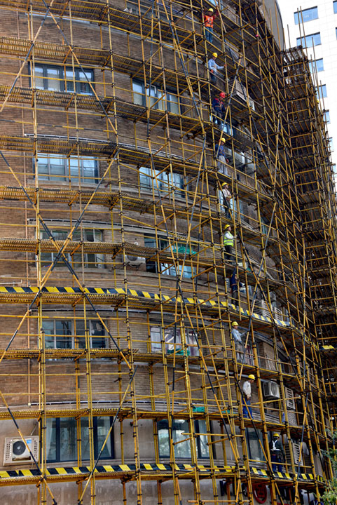 workers on scaffolding around a tall building