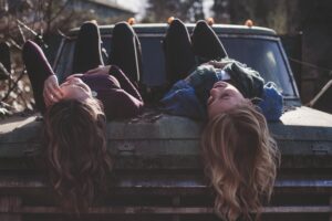 Two women lie on a truck hood
