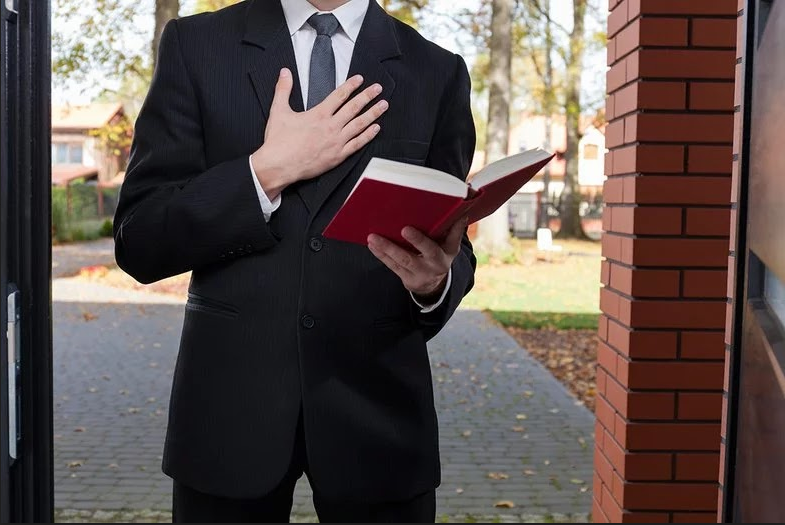 Faceless man in suit with one hand on his chest and one holding an open book