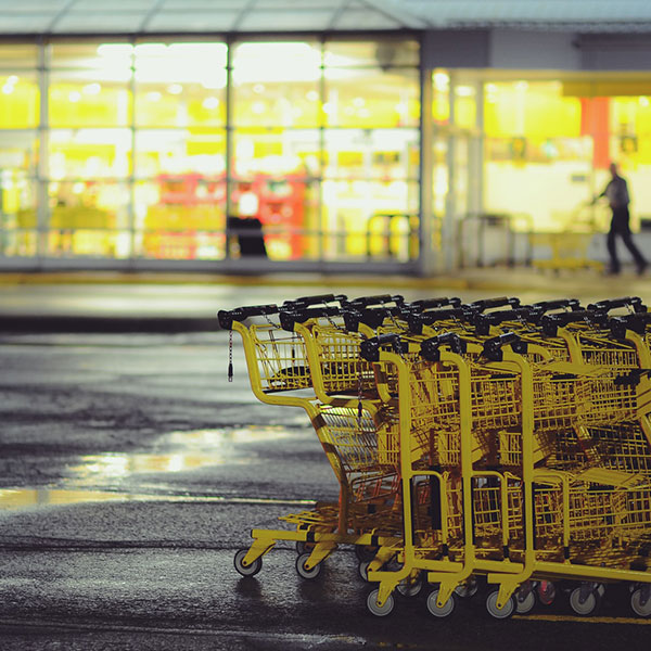 Photo of yellow shopping carts stacked together in a wet parking lot