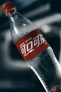 Tipped Bottle of Chinese Coca Cola Against Blurred Background