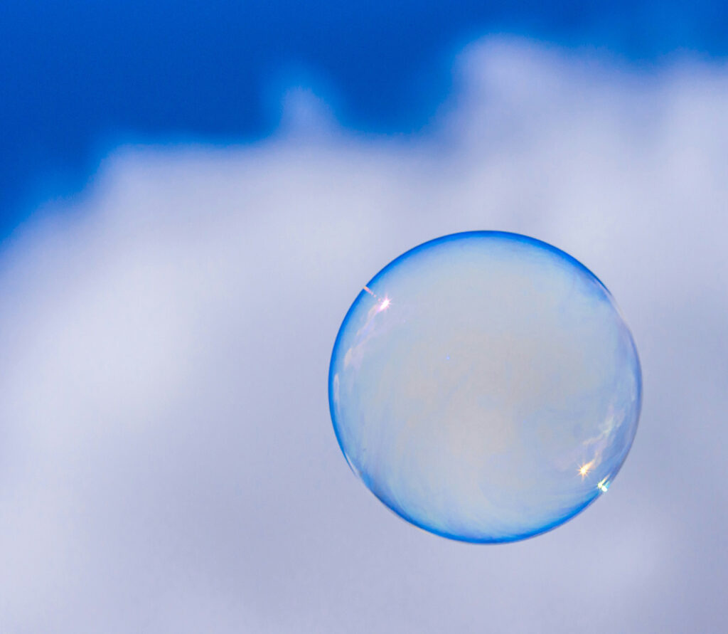 Translucent blue bubble against a partly cloudy blue sky.