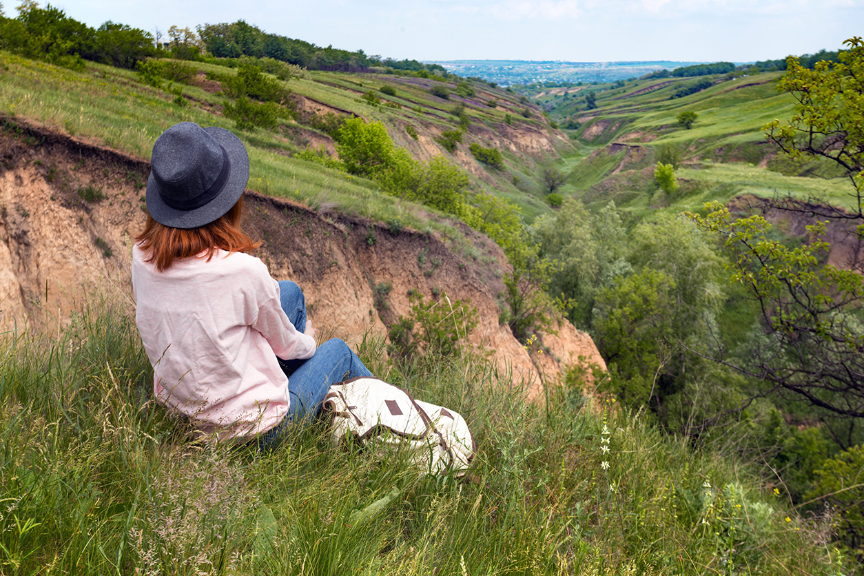 Photo of a teenager looking out over a grassy valley in Moldova.
